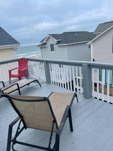 a deck with a bench and a chair on a balcony at Endless Summer Beach House in Myrtle Beach