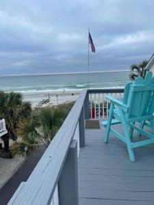 a blue rocking chair sitting on a porch overlooking the beach at Endless Summer Beach House in Myrtle Beach
