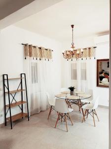 comedor con mesa, sillas y lámpara de araña en Violeta Suite en Madrid