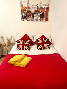 a red bed with two pillows and a red blanket at 2 Bed flat near to London Bridge in London