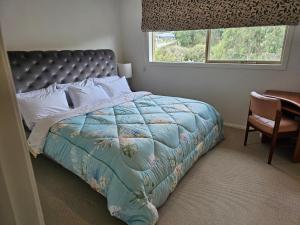 a bedroom with a bed and a window and a chair at Timeless Safaris in Botanic Ridge