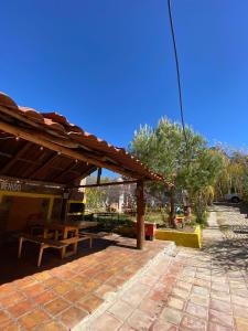 un patio con un pabellón de madera y un banco en Cabaña San Juanita, en Los Lirios