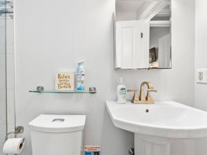 a white bathroom with a sink and a mirror at Fresh Pond Chateau Renovated Bright and Cozy Home in Oak Bluffs