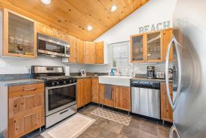 a kitchen with wooden cabinets and a stainless steel refrigerator at Fresh Pond Chateau Renovated Bright and Cozy Home in Oak Bluffs