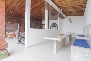 uma cozinha com paredes brancas e um tecto de madeira em Pondok DD Canggu em Canggu