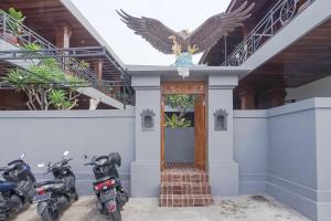 two motorcycles parked in front of a building with an eagle on the ceiling at Pondok DD Canggu in Canggu