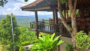 een gebouw met een balkon met uitzicht op het bos bij Bali Rahayu Homestay in Munduk