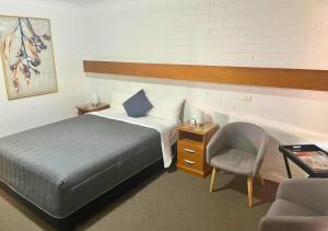 米爾杜拉的住宿－歐羅娜汽車旅館，一间卧室配有一张床、一把椅子和一张书桌