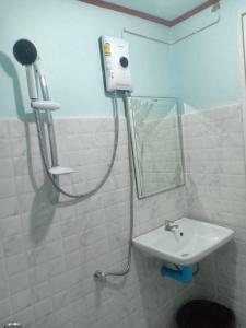 La salle de bains est pourvue d'une douche et d'un lavabo. dans l'établissement chill chill long beach hostel, à Ko Lanta