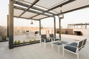 a patio with chairs and tables on a roof at Stella Stays Olaya Tower 1 in Riyadh