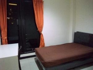 um quarto com uma cama e uma janela com uma cortina laranja em villa puncak tidar cece em Kasri