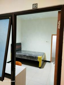 uma cama num quarto com uma placa na parede em villa puncak tidar cece em Kasri