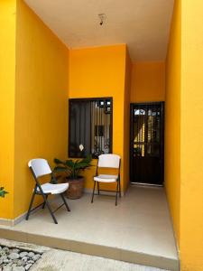 two chairs sitting on the porch of a house at Casa de la esquina in Santa María del Oro