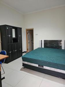 a bedroom with a bed and some black cabinets at villa puncak tidar cece in Kasri