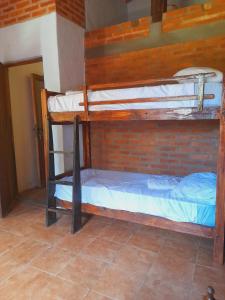 Ce lit se trouve dans un dortoir doté de 2 lits superposés et d'un mur en briques. dans l'établissement Cabaña Lo de Sergio, à Colonia Carlos Pellegrini