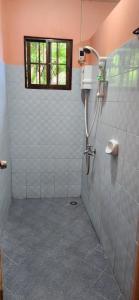 a bathroom with a shower with a window at Sandra's holiday house in Oslob