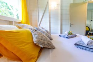 - un lit avec 2 oreillers et des serviettes dans l'établissement Bord de Rivière & Piscine Privée - TiKaz Twopikal, à Sainte-Rose