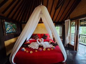 a bedroom with a bed with a mosquito net at Bali Rahayu Homestay in Munduk