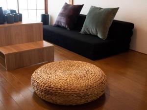 東京的住宿－Lido Urayasu，客厅配有黑色沙发和搁脚凳
