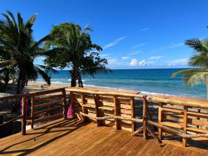 Beach Cabarete Lodge Eco De Luxe Surf, Kite, Yoga في كاباريتي: سطح خشبي مطل على الشاطئ