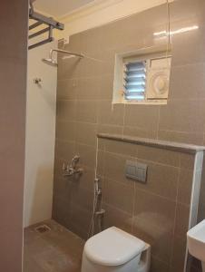 a bathroom with a toilet and a shower with a window at A.R Residency in Chennai