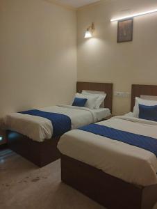 um quarto com 2 camas com lençóis azuis e brancos em A.R Residency em Chennai