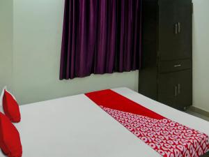 a bedroom with a bed with a red and white blanket at Flagship Hotel The Guest Land in Visakhapatnam