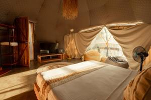 a bedroom with a large bed with a tent at Domes and Dreams Lio Glamping in El Nido