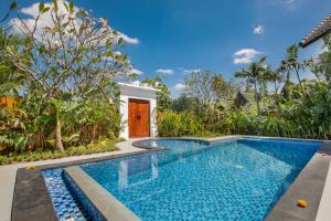 a swimming pool in front of a villa at Villa Tramonto By Le Cielo in Canggu
