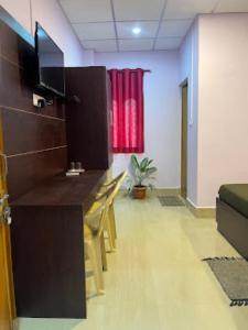 ニール島にあるPurnima Residency , Lakshmanpurのデスク、椅子、赤いカーテンが備わる客室です。