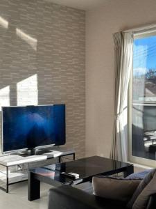 een woonkamer met een grote flatscreen-tv bij 71 Mt view - A棟 - in Fujikawaguchiko