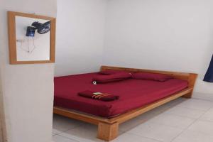 Cama en habitación con colchón rojo en OYO Life 93015 Kos Anto, en Pawenang