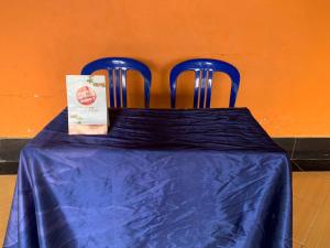 two blue chairs at a table with a blue table cloth at OYO Life 93259 Kos Kurnia in Tanjung