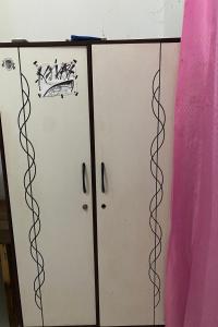 a pair of white cabinets with graffiti on them at OYO Life 93259 Kos Kurnia in Tanjung