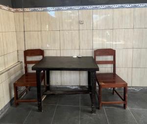 a wooden table and two chairs and a table at OYO Life 93255 Kosan Teratai Jaya in Tanjung