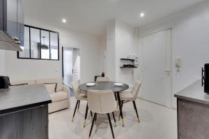 cocina y sala de estar con mesa y sillas en Comfortable apartment Marx Dormoy, en París