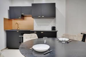 una cocina con una mesa negra con un plato blanco. en Comfortable apartment Marx Dormoy, en París