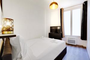 una camera con un letto bianco e una finestra di Comfortable apartment Marx Dormoy a Parigi