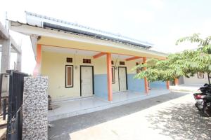 a small building with orange and blue paint at OYO Life 93260 Bale Kosan in Tanjung