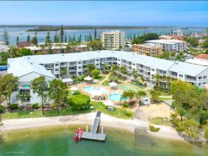 an aerial view of a resort with a boat in the water at Pelican Cove Apartments in Gold Coast