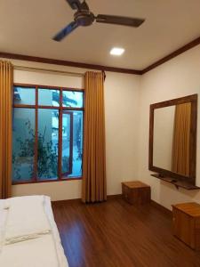 a bedroom with a bed and a large window at Oi Beach in Maamigili