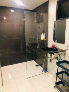 ein Bad mit einer Dusche und einer Glastür in der Unterkunft 2 bedrooms Apartment in Pantai Cenang