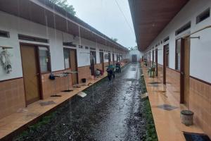 BanyumasにあるSPOT ON 93553 Juan Kostelの雨の中の建物の空廊