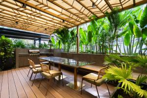 un patio con mesa, sillas y plantas en Zenity 3BR Condo: Luxury and Comfort in Quận 1, en Ho Chi Minh