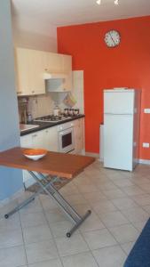 ヴァッレドーリアにあるApartment Residence Valledoria 2の白い冷蔵庫付きのキッチン、壁掛け時計