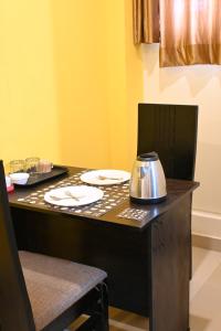 una mesa con platos y un hervidor de agua. en Hotel SY Comforts en Bangalore