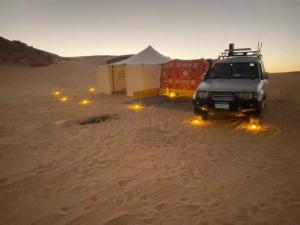 a truck parked in the sand in the desert at Nuba falcon in Aswan