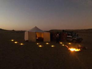 a tent and a truck in the desert at night at Nuba falcon in Aswan