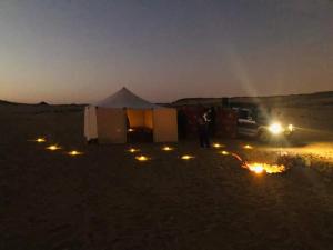 człowiek stojący przed namiotem na pustyni w obiekcie Nuba falcon w mieście Aswan