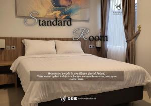Postel nebo postele na pokoji v ubytování The Safiina Point Syariah Hotel